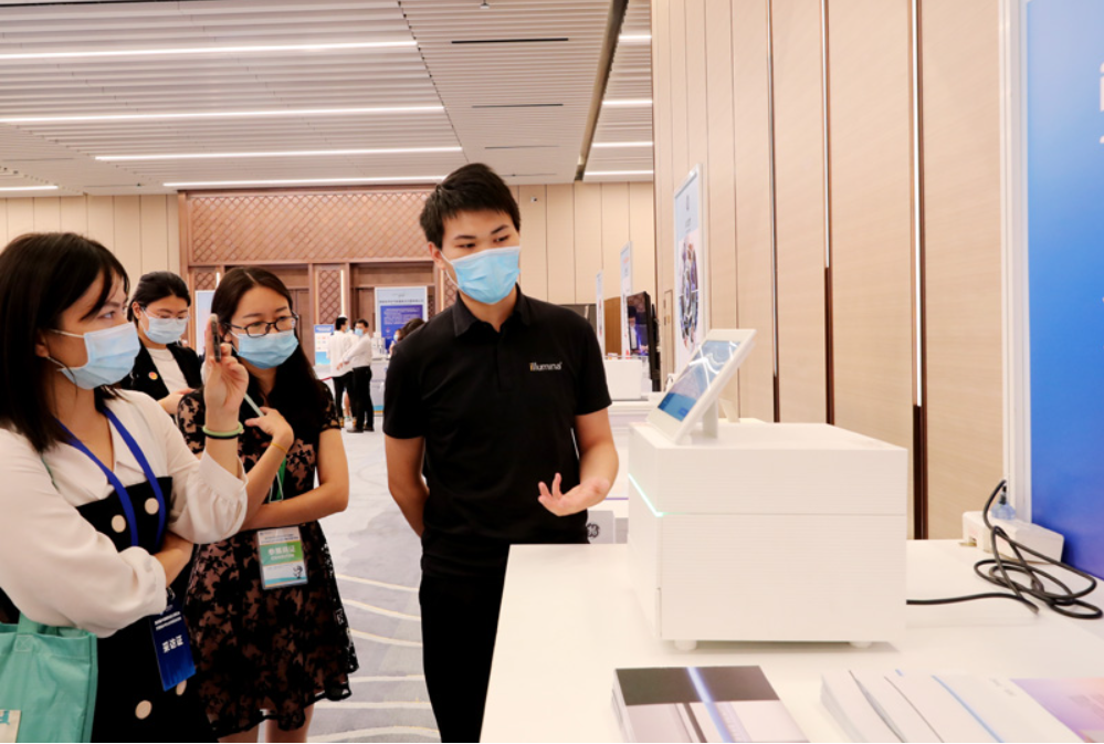 第四屆進(jìn)博會(huì)食品及農(nóng)產(chǎn)品展區(qū)、醫(yī)療器械及醫(yī)藥保健展區(qū)展前供需對(duì)接會(huì)的工作人員在介紹一臺(tái)測(cè)序儀展品